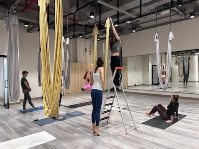 AntiGravity instructor and Cirque du Soleil trainer Hellen Zabal sizes the swing for an aerial yoga participant.