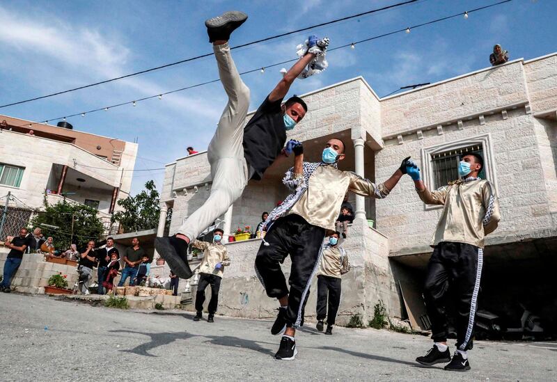 Dancers of the Palestinian Jafra Dabke Team perform a traditional dabke dance  for people confined because of the coronavirus pandemic lockdown in the village of Tarqumia, north-west of Hebron, in the occupied West Bank. AFP