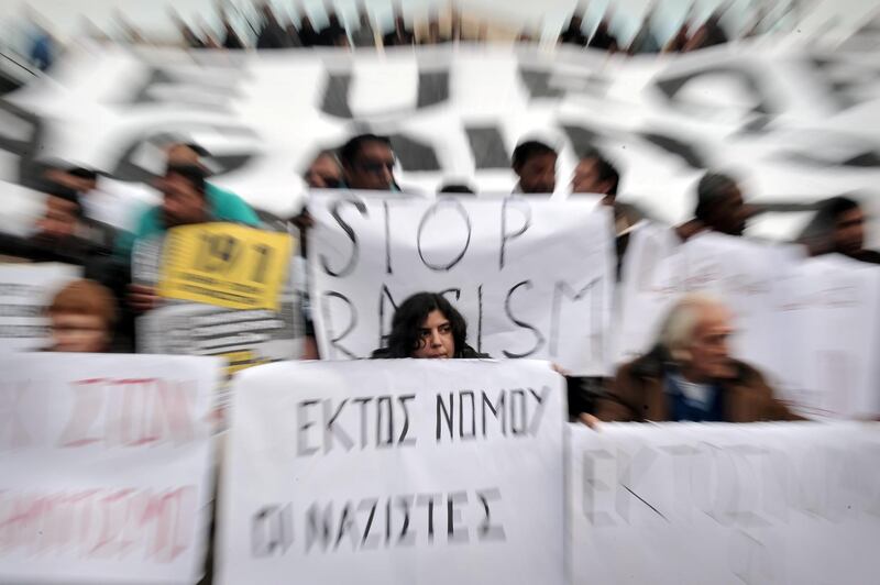 Demonstrators hold placards during a march for democracy, against racism, antisemitism and neo-Nazism in front of the greek Parliament in Athens, on December 15, 2012.    AFP PHOTO / LOUISA GOULIAMAKI (Photo by LOUISA GOULIAMAKI / AFP)