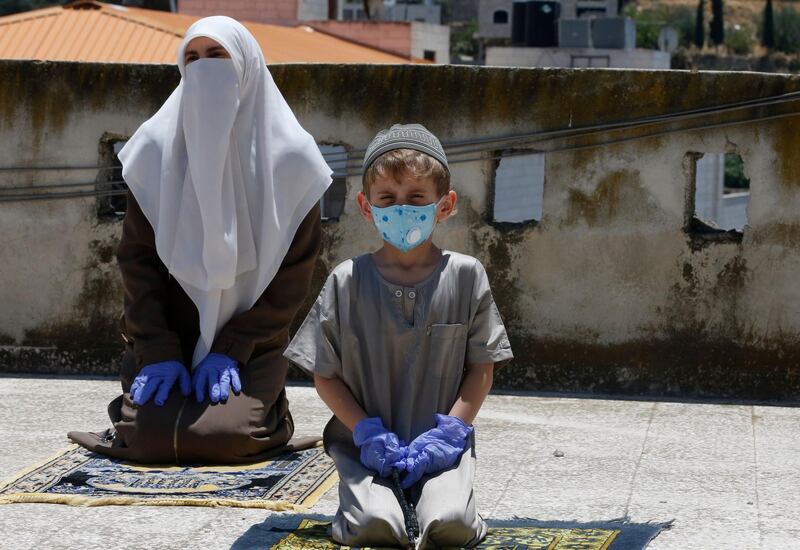 Members of the family of an imam at a local mosque, perform their Friday prayers on the rooftop of their house, after the authorities shut down mosques due to the coronavirus pandemic, in the West Bank town of Hebron. AFP