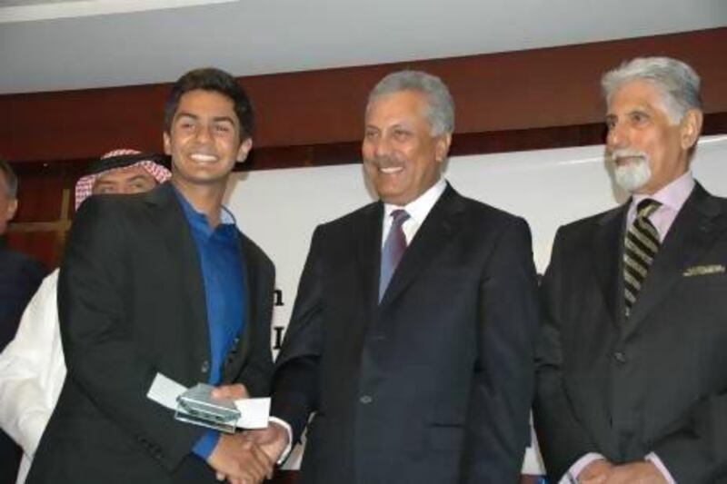 Dubai 16-year-old Shorye Chopra, left, accepts an award as top junior cricketer and a handshake from former Pakistan international player Zaheer Abbas, centre, as Shyam Bhatia looks on.