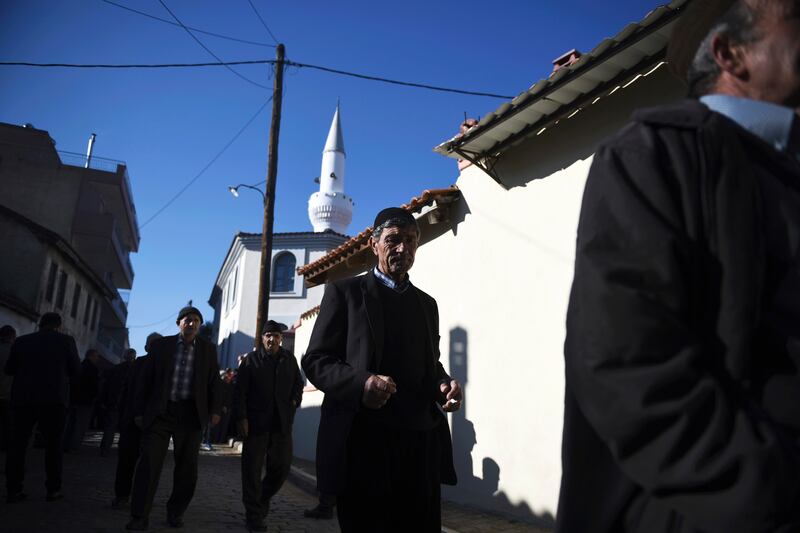 In this Friday, Dec. 8, 2017 file photo, pilgrims walk outside Kirmahalle Cammi mosque in the northeastern Greek town of Komotini. Lawmakers in Greece are set to limit powers of Islamic courts which operate in a border region of the town of Komotini that is home to a 100,000-strong Muslim minority, following a European court challenge. (AP Photo/Giannis Papanikos, File)