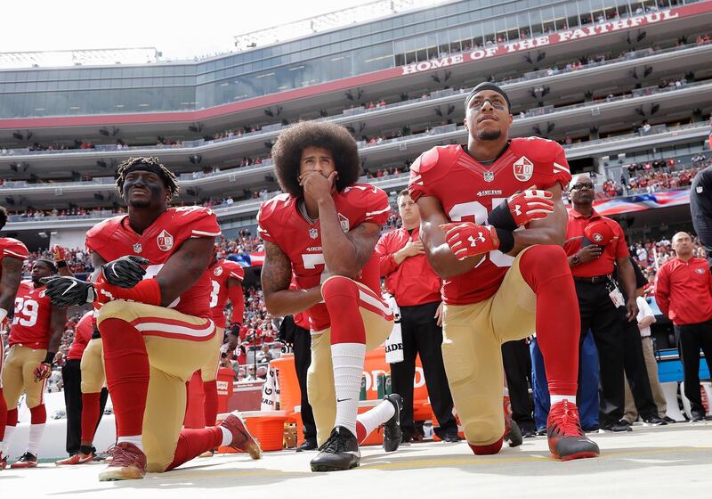 FILE - In this Oct. 2, 2016 file photo, from left, San Francisco 49ers outside linebacker Eli Harold, quarterback Colin Kaepernick and safety Eric Reid kneel during the national anthem before an NFL football game against the Dallas Cowboys in Santa Clara, Calif. An arbitrator is sending Kaepernick's grievance with the NFL to trial, denying the league's request to throw out the quarterback's claims that owners conspired to keep him out of the league because of his protests of social injustice.  (AP Photo/Marcio Jose Sanchez, File)