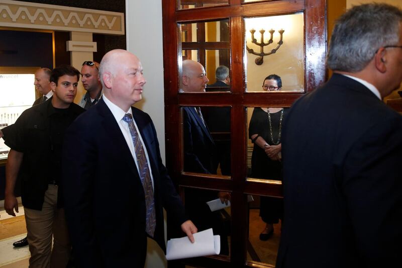 Jason Greenblatt (C), US President Donald Trump's Middle East envoy, is reflected in a mirror as he enters a room to hold a news conference with Israeli Minister of Regional Cooperation and the head of the Palestinian Water Authority, in Jerusalem on July 13, 2017. / AFP PHOTO / POOL / RONEN ZVULUN