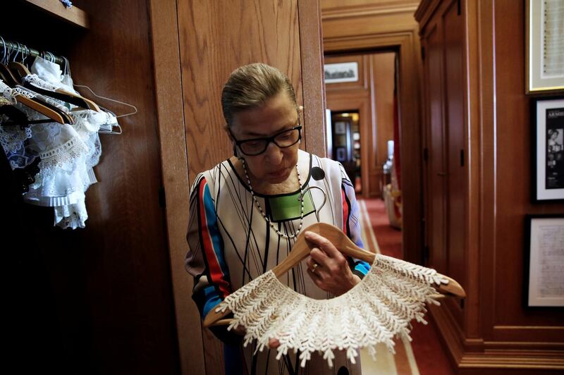 US Supreme Court Justice Ruth Bader Ginsburg shows the many different collars she wore with her robes, in her chambers at the Supreme Court building in Washington on June 17, 2016. Reuters