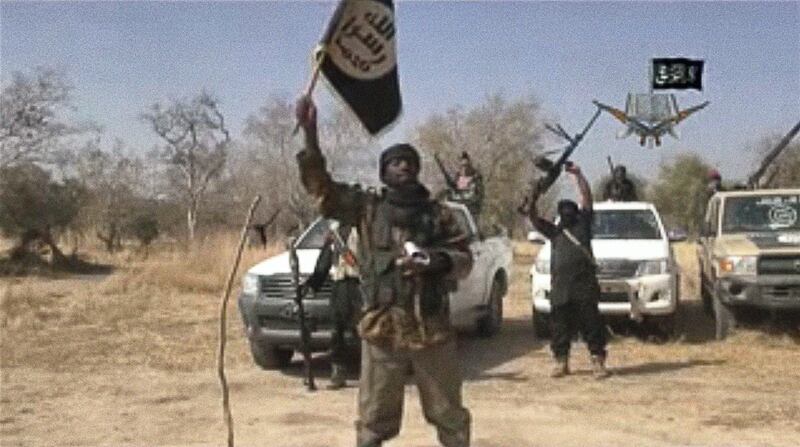 A screen grab made on January 20, 2015 from a video of Nigerian Islamist extremist group Boko Haram obtained by AFP shows the leader of the Islamist extremist group Boko Haram Abubakar Shekau holding up a flag as he delivers a message. Boko Haram has claimed a massive attack feared to be the worst in its six-year insurgency and threatened Nigeria's neighbours, as talks began for a regional response to the militants and fears grew of further violence. "We killed the people of Baga. We indeed killed them, as our Lord instructed us in His Book," Shekau said in the 35-minute message, which was posted on YouTube. AFP PHOTO / BOKO HARAM

-- RESTRICTED TO EDITORIAL USE - MANDATORY CREDIT "AFP PHOTO / BOKO HARAM" - NO MARKETING NO ADVERTISING CAMPAIGNS - DISTRIBUTED AS A SERVICE TO CLIENTS -- (Photo by - / BOKO HARAM / AFP)