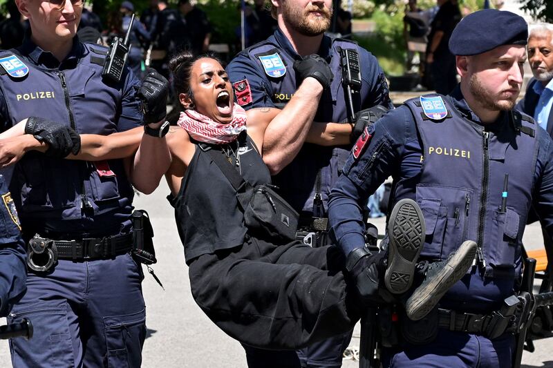 Policemen carry away a woman from a protest encampment for Palestine, set up by students protesting the war in Gaza on the campus of the Vienna Univesity of Technology. AFP