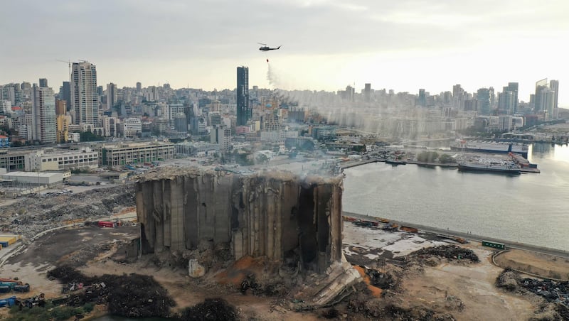 A Lebanese Army helicopter releases water over the heavily damaged grain silos at the port of the capital Beirut, after a partial collapse due to a fire. AFP