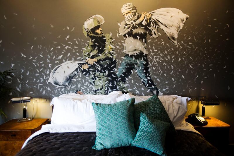 A Banksy wall painting showing an Israeli border police officer and a Palestinian in a pillow fight decorates one of the rooms of The Walled-Off Hotel in the West Bank city of Bethlehem. AP, File