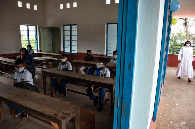 Students wait for classes to begin and a teacher arrives.