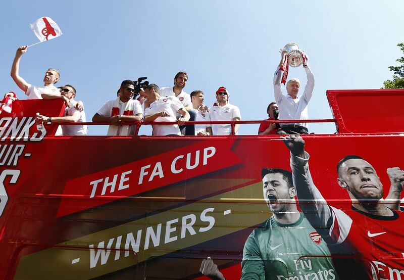 Arsenal manager Arsene Wengerholds the FA Cup trophy during a victory parade after Arsenal won the FA Cup final against Hull City at Wembley Stadium on Saturday, in London May 18, 2014. Andrew Winning / Reuters