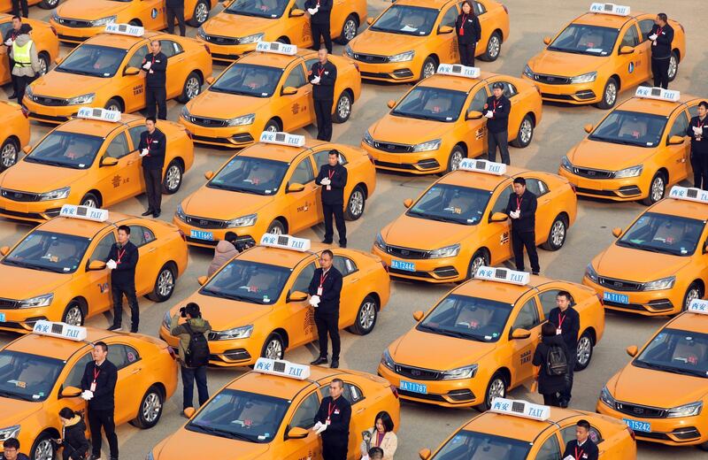 People attend an unveiling ceremony for a fleet of new methanol-fuelled taxis, developed by Geely, in Xian, Shaanxi province, China. Reuters