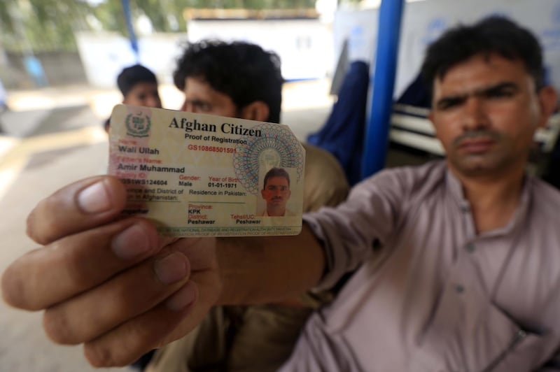 An Afghan refugee shows his temporary registration card as he waits to return to his country at a UN registration centre in Azakhel area of Nowshera, Khyber Pakhtunkhwa province, Pakistan. EPA