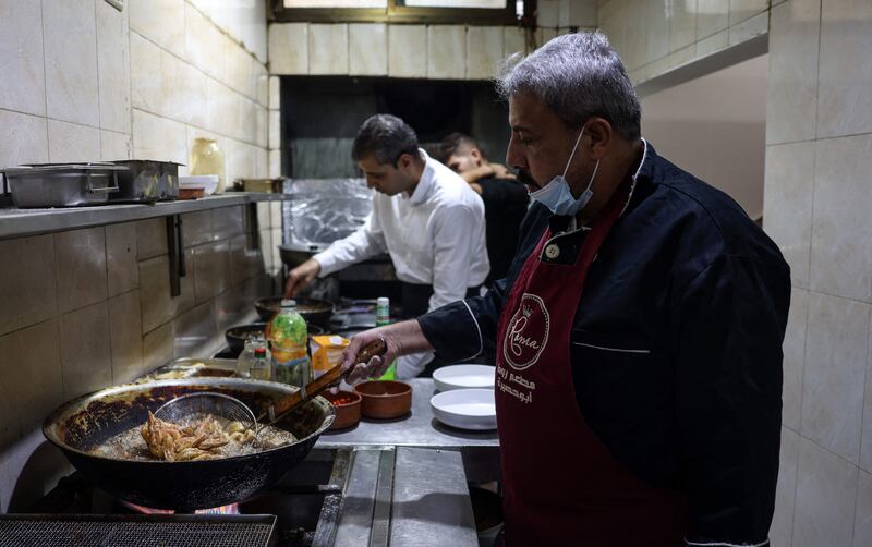 Mustapha Abu Hassira, left, and his staff work in the kitchen of Roma fish restaurant owned by the Abu Hassira family in Gaza City.