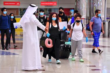 Tourists arrive at Dubai airport in the United Arab Emirates on July 8, 2020, as the country reopened its doors to international visitors in the hope of reviving its tourism industry after a nearly four-month closure. (Photo by GIUSEPPE CACACE / AFP)