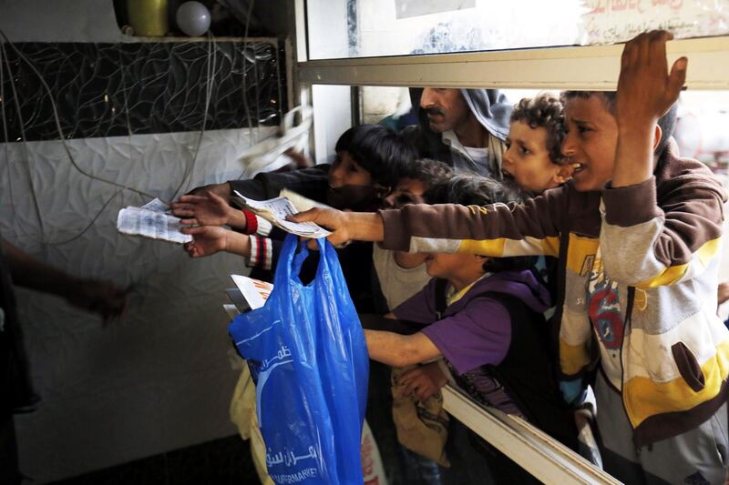 Conflict-ridden people wait to get their families' free food ration from a charity kitchen in Sana'a, Yemen.  EPA