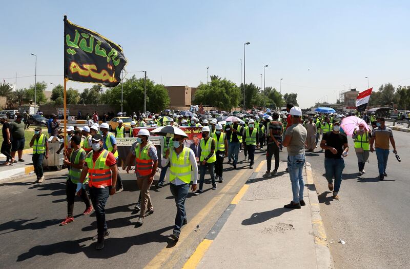 Jobless graduates wear hard hats and fluro vests during a protest near the green zone in central Baghdad, Iraq.  EPA