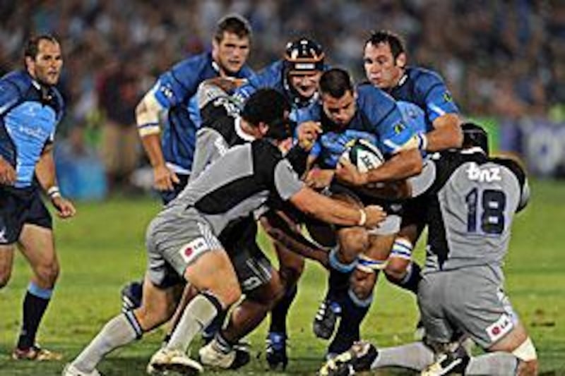 Pierre Spies, centre, the Bulls No 8, is tackled by Bryn Evans and John Schwalger of the Hurricanes during Pretoria's 19-18 win at Loftus Versfeldt last weekend.