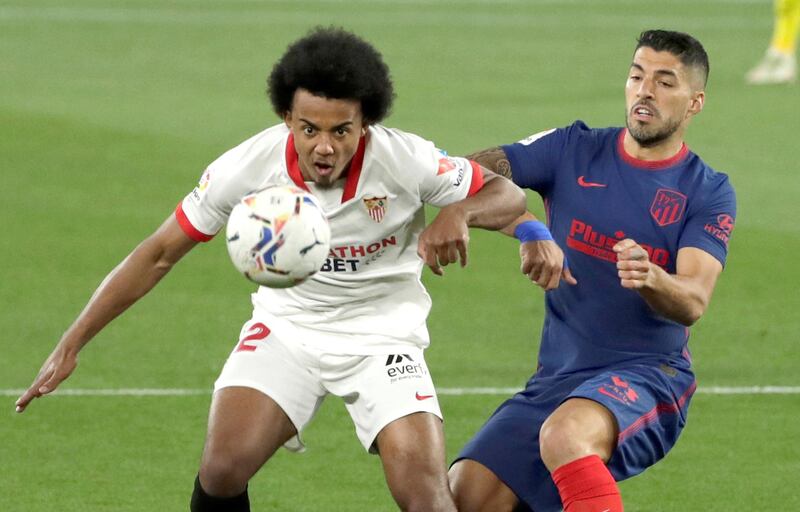 Sevilla's French defender Jules Kounde, left, vies for the ball against Atletico's Uruguayan striker Luis Suarez. EPA