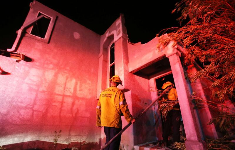 Firefighters work at a home destroyed by the Tick Fire in Canyon Country. AFP