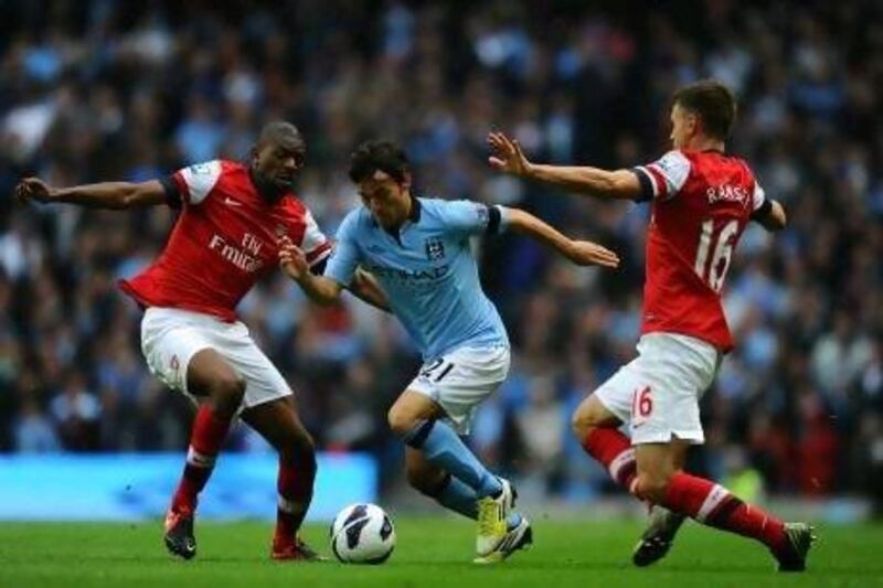 David Silva, the Manchester City midfielder, is shut down by Abou Diaby and Aaron Ramsey, the Arsenal duo. Laurence Griffiths / Getty Images