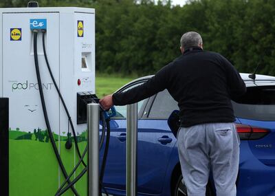 A man plugs in a Vauxhall electric car at a Pod Point electric vehicle rapid charging station in Wallasey. Reuters 