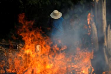 A man works in a burning tract of Amazon jungle as it is being cleared by loggers and farmers in Iranduba, Amazonas state. Reuters