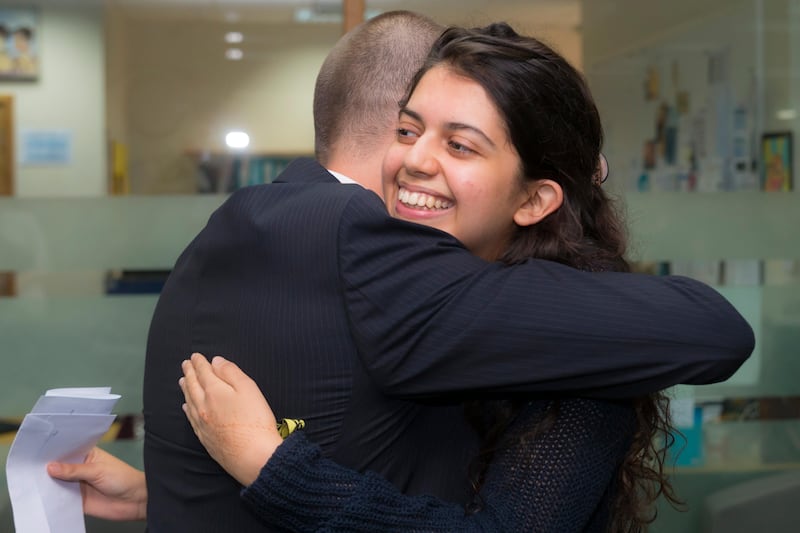 Sara Dube of Jumeirah English Speaking School hugs Ian Thurston, the deputy head of KS5 at JESS. Sara scored  a perfect 45 in her IB test results. Navin Khianey for The National