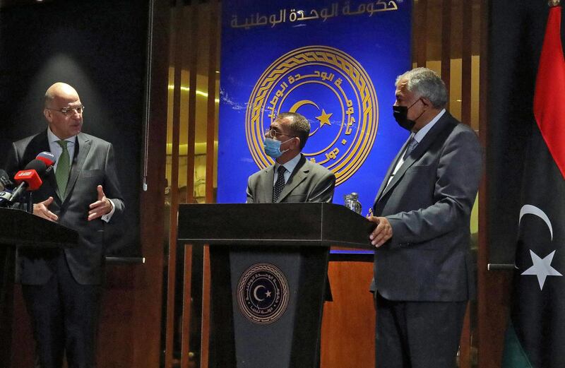 Libya's deputy Premier Hussein Attiya al-Gotrani(R) and Greek Foreign Minister Nikos Dendias hold a press conference in the eastern city of Benghazi, on April 12, 2021.  / AFP / Abdullah DOMA
