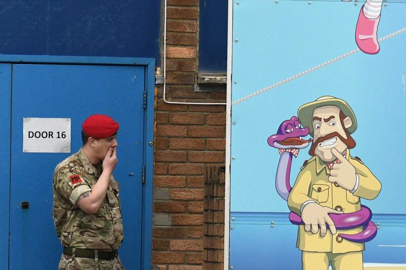 A member of the military stands alongside a Welcome billboard at Pontins. AFP