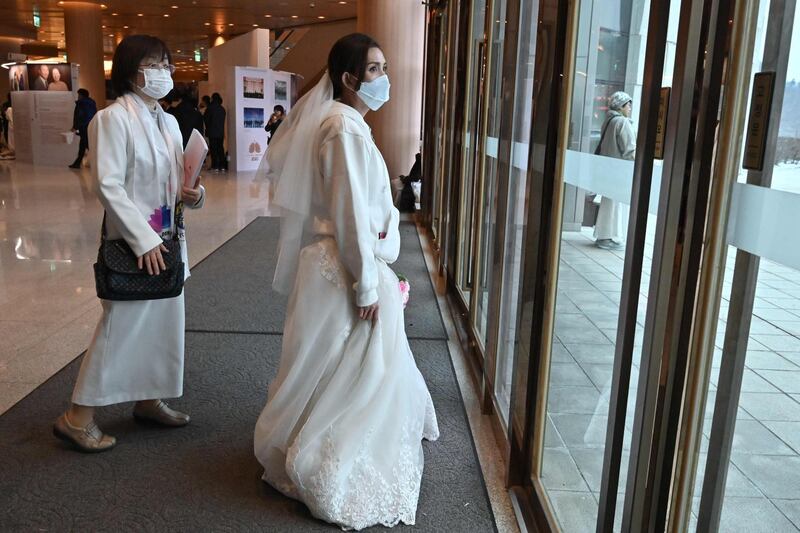 A bride wearing a protective face mask attends a mass wedding ceremony organised by the Unification Church at Cheongshim Peace World Center in Gapyeong. AFP