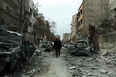 A picture taken on February 25, 2018, shows a Syrian man walking next to damaged buildings following regime air strikes in the Syrian rebel-held town of Douma, in the besieged Eastern Ghouta region on the outskirts of the capital Damascus.
New regime air strikes and heavy clashes shook Syria's rebel enclave of Eastern Ghouta on Sunday despite a UN demand for a ceasefire to end one of the most ferocious assaults of Syria's civil war. / AFP PHOTO / HAMZA AL-AJWEH