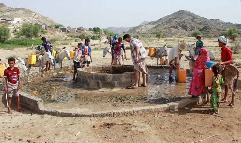 Yemenis fill their jerrycans carried by donkeys with water from a cistern at a make-shift camp for the internally displaced in the northern Hajjah province. AFP