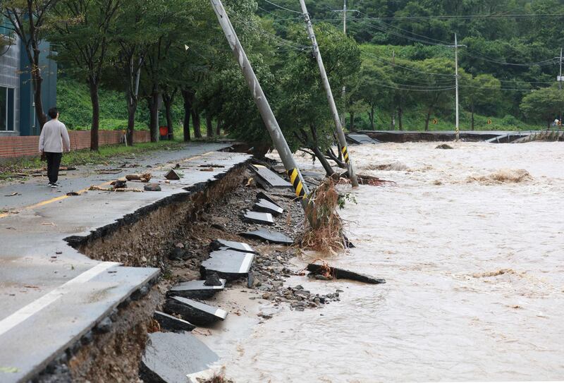 A man walks along a damaged road in Gyeongju on September 6, 2022, as Typhoon Hinnamnor hit South Korea's southern provinces.  (Photo by YONHAP  /  AFP)  /  - South Korea OUT  /  REPUBLIC OF KOREA OUT  NO ARCHIVES  RESTRICTED TO SUBSCRIPTION USE