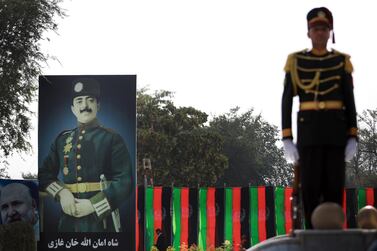 An Afghanistan guard of honour officer stands next to the billboard of King Amanullah Khan, who led Afghanistan to independence. EPA