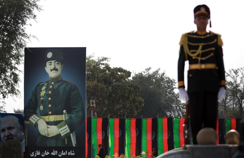 epa08610242 An Afghanistan guard of honor officer stands next to the King Amanullah Khan billboard, who led Afghanistan to independence, during a ceremony to mark Independence Day at the Defense Ministry in Kabul, Afghanistan, 18 August 2020. Afghanistan is celebrating the 101st anniversary of its independence from British rule on 18 August.  EPA/JAWAD JALALI