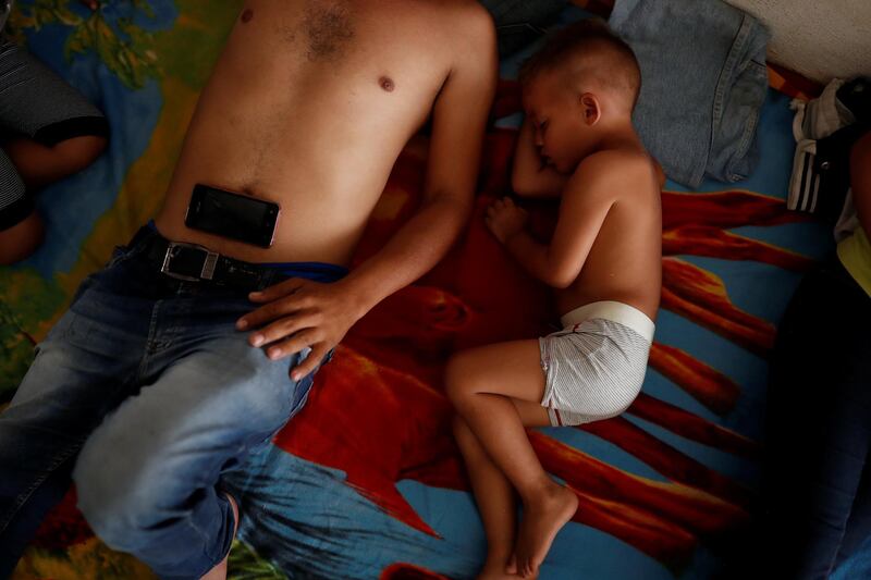 Dilan Matinez, 3, sleeps next to his father Oscar Martinez, a migrant from Honduras. Reuters