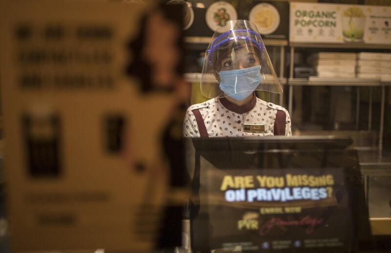 Employees wear protective masks to serve customers at food counters in the PVR Icon cinema at the DLF Promenade Mall in New Delhi, India. Millions of filmgoers are excitedly waiting for cinemas to reopen this week after a seven-month pandemic-induced halt. Bloomberg
