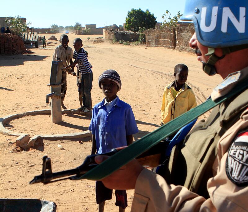 Children stand next to a UN peacekeeper at the Abu Shok camp.   AFP