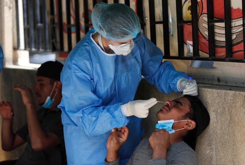 A nurse tests a Bangladeshi worker for the coronavirus in Beirut, Lebanon. AP Photo
