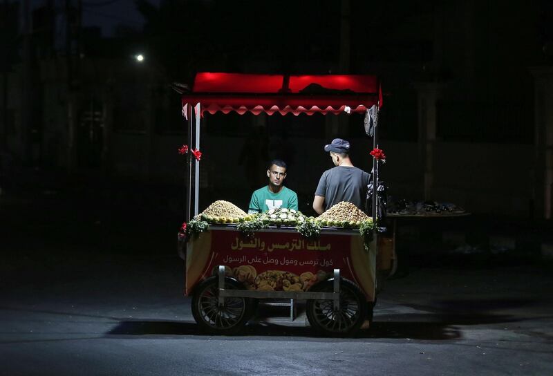 Palestinian vendors wait for customers behind their stall in Gaza City.  AFP