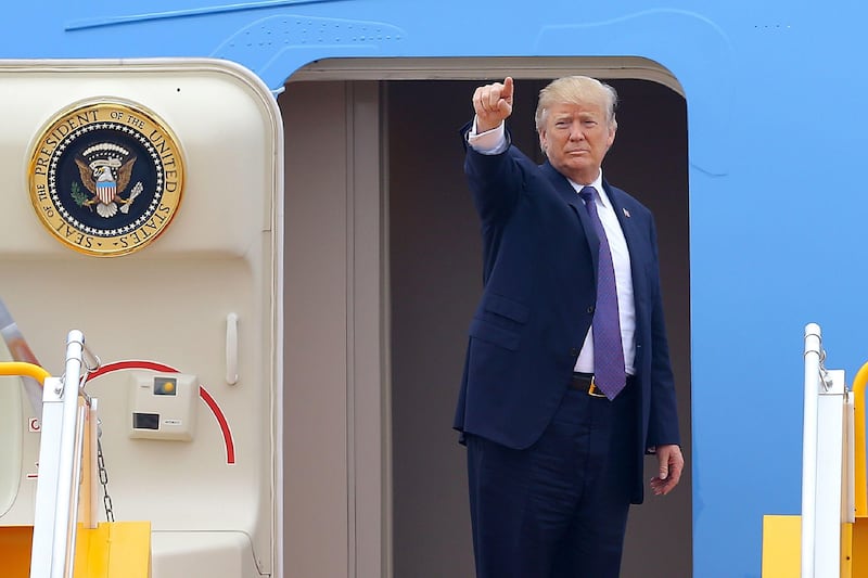 US President Donald Trump gestures before boarding Air Force One to depart to the Philippines, at the airport in Hanoi on November 12, 2017.
Trump told his Vietnamese counterpart on November 12 he is ready to help resolve the dispute in the resource-rich South China Sea, which Beijing claims most of. / AFP PHOTO / POOL / MINH HOANG