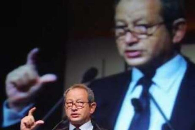 Orascom chairman and chief executive Naguib Sawiris speaks in front of a live image of himself during the opening session of the 3GSM World Congress Asia in Singapore on Monday, October 16, 2006.     Photographer: Jonathan Drake/Bloomberg News
