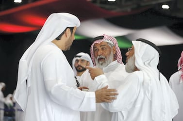 Emirati men greet each other before casting their votes for this year's FNC elections at Adnec in Abu Dhabi. Chris Whiteoak / The National