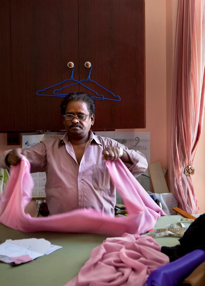 Master cutter Marimuthu Thangavelu Marimuthu, or, as customers know him, Vilu, folds silk while he works at the Dar al Bateen for High Fashion, a custom tailoring shop in the Khalidiya neighborhood in Abu Dhabi on Monday morning, August 1, 2011, the first day of Ramadan. (Silvia Razgova/The National)

