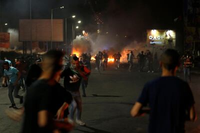 TOPSHOT - Palestinian demonstrators run away from the gas fired by Israeli soldiers during an anti-Israel demonstration over tensions in Jerusalem near the Jewish settlement of Beit El near Ramallah in the occupied West Bank, on May 13, 2021. A Palestinian man was killed during a confrontation with Israeli soldiers near the northern West Bank city of Nablus, the Palestinian health ministry said on May 13, as violence soars in the occupied territories. The death brings the number killed in clashes between Palestinians and Israeli forces in the West Bank to three on Wednesday alone. / AFP / ABBAS MOMANI
