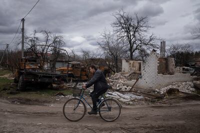 Destroyed vehicles and an apartment building in Yahidne, Ukraine. AP
