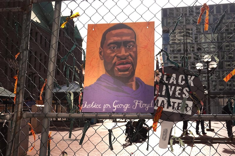 MINNEAPOLIS, MINNESOTA - MARCH 30: A picture of George Floyd hangs on a fence barrier that surrounds the Hennepin County Government Center as the trial of former Minneapolis police officer Derek Chauvin continues on March 30, 2021 in Minneapolis, Minnesota. Chauvin is accused of murder in the death of George Floyd. Security is heightened in the city in an effort to prevent a repeat of violence that occurred in Minneapolis and major cities around the world following Floyd's death on May 25, 2020.   Scott Olson/Getty Images/AFP
== FOR NEWSPAPERS, INTERNET, TELCOS & TELEVISION USE ONLY ==
