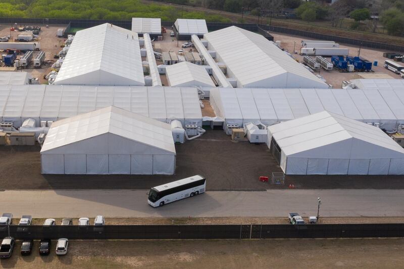 A tour bus exits a U.S. Customs and Border Protection temporary processing center after dropping off migrants in Donna, Texas, U.S., March 15, 2021. Picture taken with a drone.  REUTERS/Adrees Latif