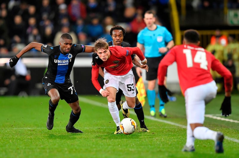 Manchester United's Brandon Williams, centre, is challenged by Club Brugge's Clinton Mata, left. AFP
